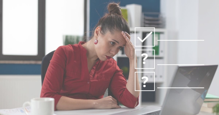 Women sitting at desk looking at her screen looking frustrated